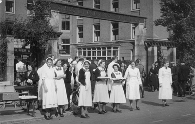 600715 Afbeelding van een groep verpleegsters met dienbladen vol drinkbekers voor het Stads- en Academisch Ziekenhuis ...